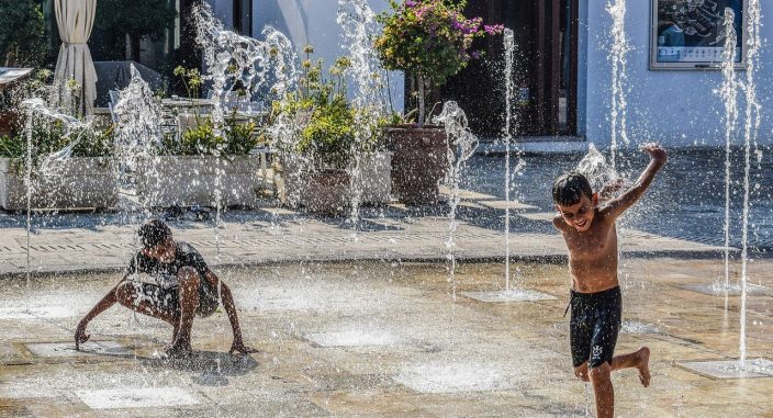boys play in fountain water
