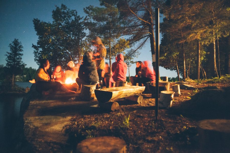 alumni group people around a campfire 