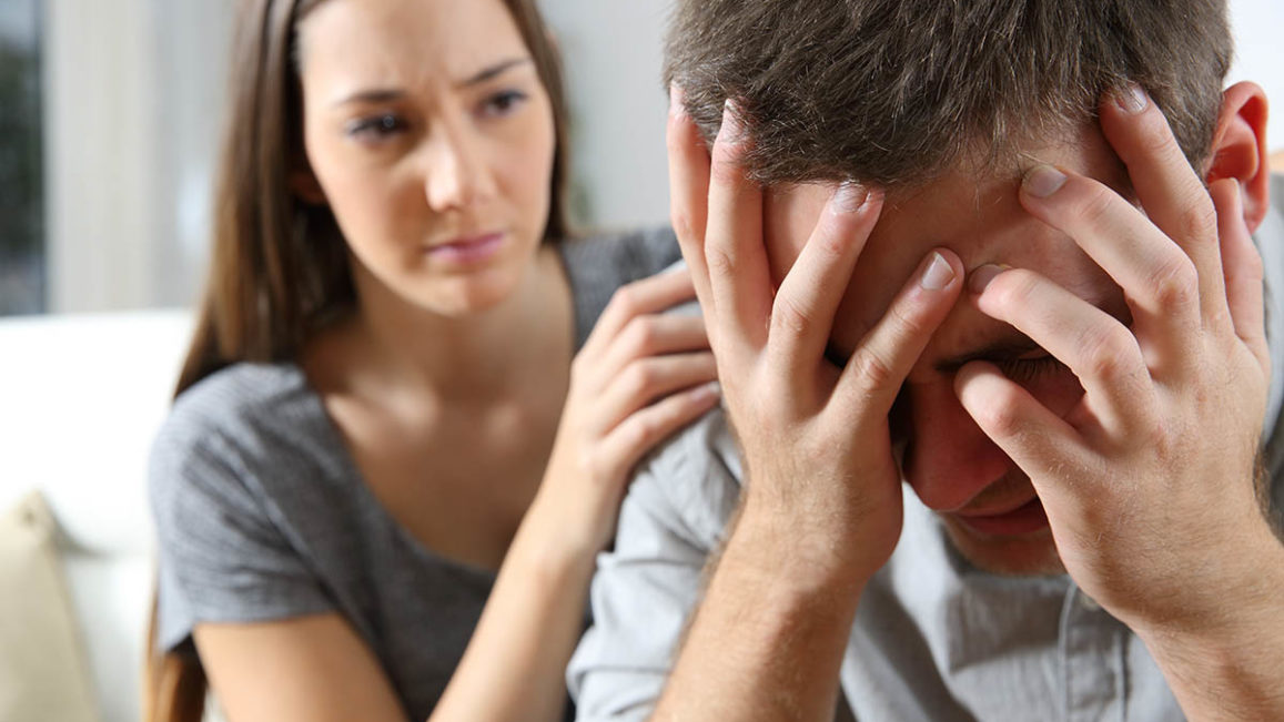 a woman consoles a man who appears distraught in his addiction relapse