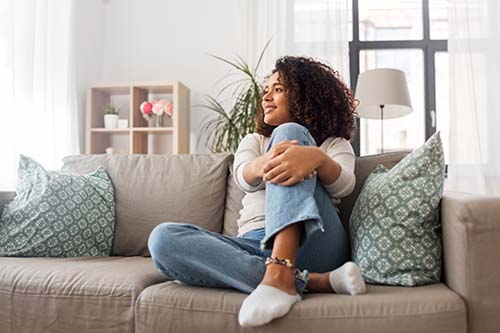 woman sitting happily on a couch