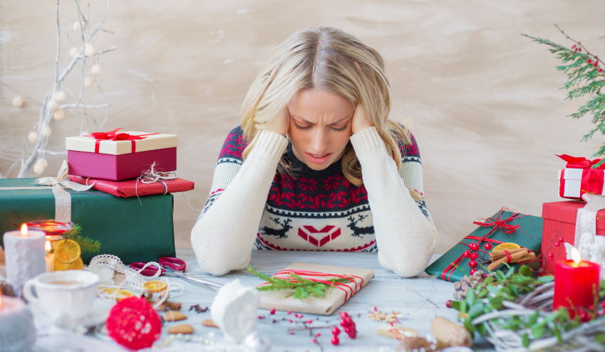 Holiday stress woman wrapping presents and looking stressed.