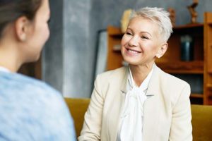 a older woman therapist smiles at her patient after explaining holistic detox treatment and its benefits