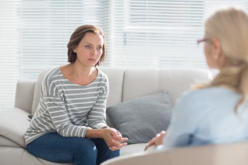 woman sits on a couch talking to her therapist about alcohol addiction treatment