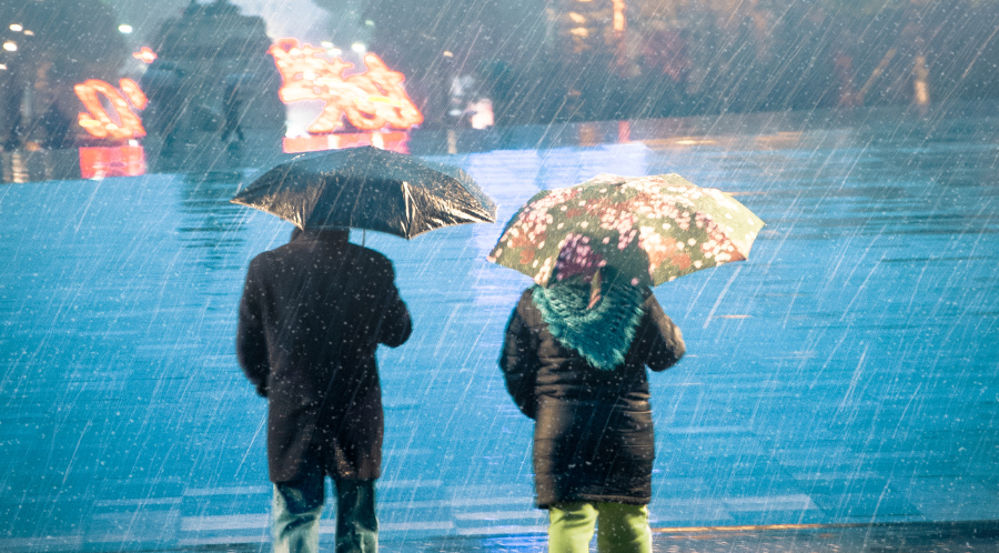 couple walking in the pouring rain to depict divorce