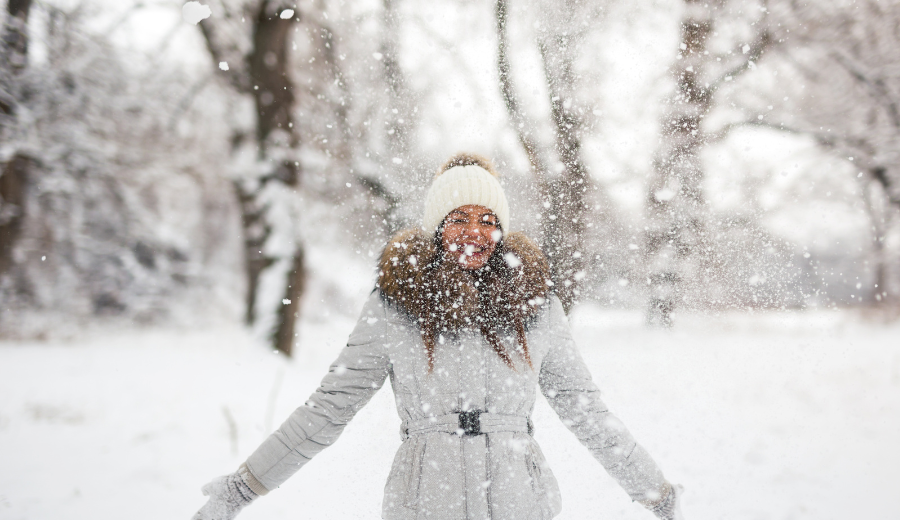 wintertime mental health bonus woman playing in snow