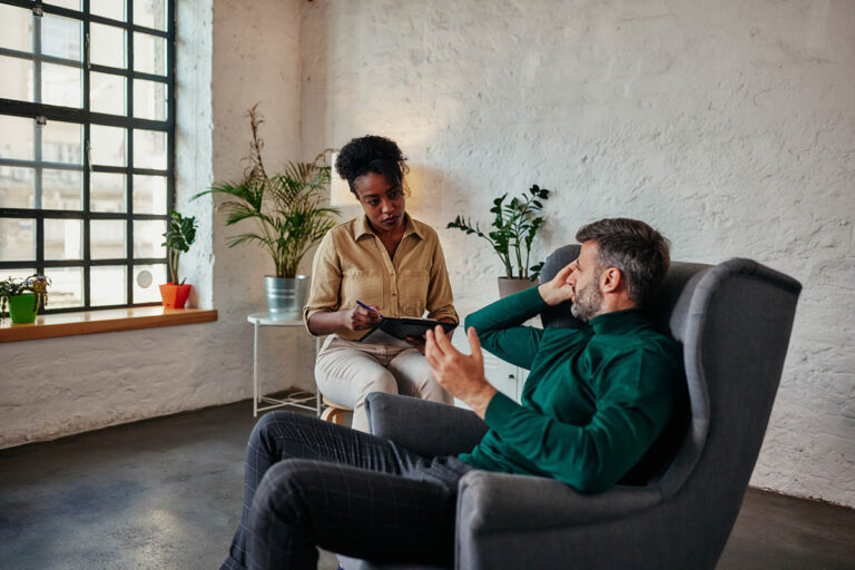 a man sits in a recliner while looking and talking to his specialist and asking the specialist what is dysphoria