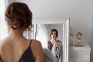 woman wearing a dress looks at herself in a mirror and wonders what is ednos