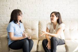 a patient and her therapist sit on a couch as the patient asks is suboxone buprenorphine and the doctor takes notes and answers her question